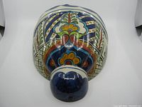 Top view showing intricate floral and geometric patterns with a glossy finish on the ceramic wall pocket.