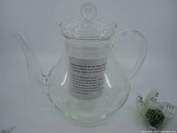 Full view of clear glass teapot with lid, showing the spout, handle, and body shape with no diffuser inside.