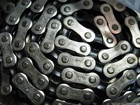 Close-up image showing multiple silver metal links stamped with 'FRANCE' as part of the Sedis Sachs bike chain.