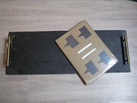 Rectangular slate board with metal handles and packaging containing four slate markers and chalk sticks on top