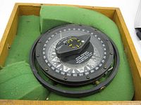 Top view of the Wood Freeman 500 Control marine pilot compass in its protective green foam-lined wooden box showing the compass dial and control knob.
