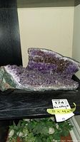 Full view of dark purple amethyst geode cluster on shelf with size label