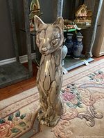 Front view of the tall ceramic cat statuette, showing the marbled glaze and upright seated posture.