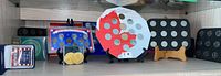 Wide view of various Canadian and US coin collections displayed on shelf, including coin sets in blue and black holders, maple leaf cardboard display, and loose coins.