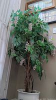 Full view of the faux tree with green leaves and light purple flowers in a white pot reaching approximately 59 inches tall.