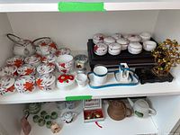 Wide view of tea set with cups, bowls, tray, and beaded bonsai tree on shelf