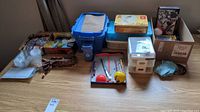 Wide view of lot showing metal tins with trading cards, plastic containers with lids, and trays holding K'nex pieces and miniatures.
