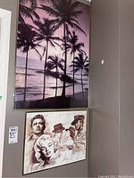 Full view of the two framed artworks on a wall: the large purple palm tree beach scene and the smaller sepia-toned watercolor print depicting classic Hollywood actors.