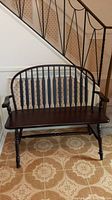 Front view of vintage hall bench showing slotted backrest, dark finish, and turned legs.