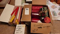 Box of 14 pairs of taper candles in assorted colors, all unlit