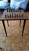 Full view of the wood chess table with chess pieces arranged on top.