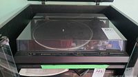 Full view of the Pioneer PL-600 turntable with attached dust cover, showing the unit's overall condition and visible dust cover hinge.