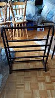 Full front view of the dark wooden quilt rack showing the frame and rails.