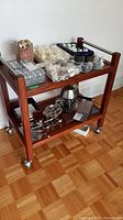 Photo of the full wooden server cart with various items placed on top and bottom shelves illustrating size and condition.