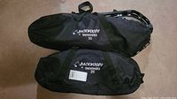 Two black fabric cases side by side labeled Backwoods Snowshoes 30 and 25