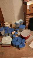 Wide shot of assorted Tupperware containers and spice rack showing size and quantity.