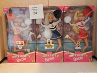 Three boxed University Barbie dolls representing Virginia, Georgia Tech, and Arizona State University cheerleaders.