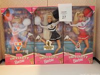 Three University Barbie cheerleader dolls in their unopened boxes representing Virginia, Georgia Tech, and North Carolina State universities with clear view of packaging and dolls.