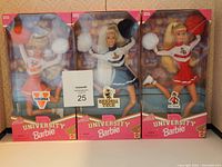 Photo of three Barbie cheerleader dolls in unopened boxes showing Virginia, Georgia Tech, and North Carolina State University themed outfits.