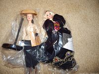 Barbie Dior 'Paris' doll and Midnight Gala doll in plastic protective sleeve showing full outfits and accessories