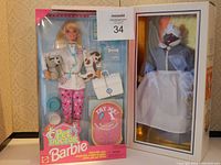 Photo showing two boxed dolls: Barbie Pet Doctor with accessories on the left, World Doll "Mammy" on the right.