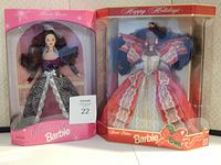 Photo showing two Barbie dolls, Winter Fantasy and Holiday Barbie, in original unopened boxes with decorative holiday-themed gowns.