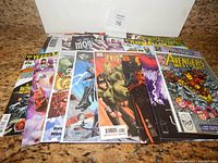 Photo showing a pile of comic books from various publishers including DC, Marvel, IDW, and Dynamite, featuring superhero titles with colorful covers.