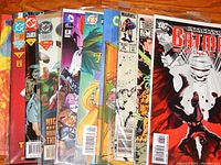 Photo of a variety of comic books from DC, Marvel, and others, showing multiple issues and publishers, some in protective sleeves.