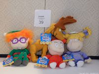 Four Nickelodeon Rugrats plush bean bags with original tags: Chuckie, Reptar, Tommy, Angelica.