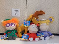 Four Nickelodeon Rugrats plush toys displayed against a patterned wall, each new with tags visible.