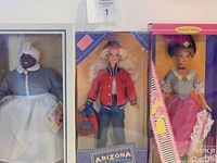 Photo showing three boxed vintage Barbie dolls: Barbie World Doll, Arizona Jean Barbie, and French Barbie Collector Edition.