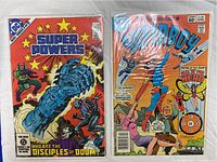 Super Powers and Superboy vintage comic book covers in plastic sleeve with board.