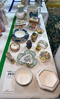 Overhead view of all porcelain and ceramic trinkets and plates arranged on a table, showcasing variety of floral designs and pieces of various sizes and shapes.