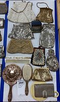 Overview of 9 vintage handbags and vanity items including mirror, brush, comb, and Tourist clock