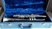 Close up of one trumpet in blue velvet-lined case showing the instrument and mouthpiece slot