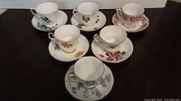 Top view of six teacups and saucers displaying various floral patterns and colors.