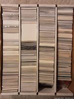 Box filled with organized stacks of many hockey cards on their backs, arranged vertically inside a long box.