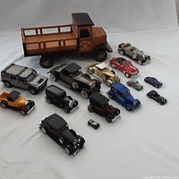 All 16 die-cast model cars displayed with the large brown Ghirardelli truck in background on white surface