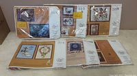 Photo of 6 Creative Circle stitchery kits, 5 sealed and 1 unsealed with visible pattern numbers and images.