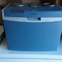 Front view of the blue Mobicool portable fridge showing vent, handle, and top design.