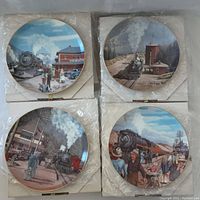 Top view of all four collector plates showing different vintage steam train scenes with originals boxes underneath.