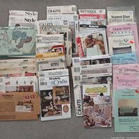 Photo of the full lot showing multiple sewing and craft patterns from brands McCall's, Simplicity, Style, Butterick, and others stacked and spread out, displaying various pattern envelope images.
