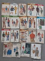 Lot of 19 vintage men's and boys' sewing patterns with illustrated envelopes showing clothing styles for men and boys