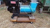Side view of the Generac alternator and motor assembly mounted on a wooden and metal wheeled dolly showing condition and assembly structure.