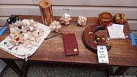 Table with six wood puzzles, wood pencil cup, owl wall art phone case, jack o lanter and pumpkin figures, tiny stuffed cat.