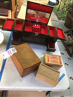 Overview of all boxes on table with jewelry box open showing compartments and mirror, and three wooden boxes placed in front