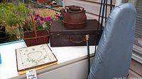 Overview of all items showing kettle on vanity case, ironing board with cover, woven basket and embroidered frame