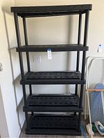 Front view of the full 6ft black plastic shelving unit with 5 shelves, showing structure and spacing.