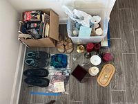 Wide shot of the lot showing shoes, candles, candle holders, decorative wraps, and box of VHS tapes
