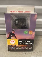 Front of the product box showing black action camera in waterproof case with 4K Ultra HD, Wi-Fi, and 2-inch screen icons.